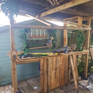 garden shed with wooden counter and hanging pots