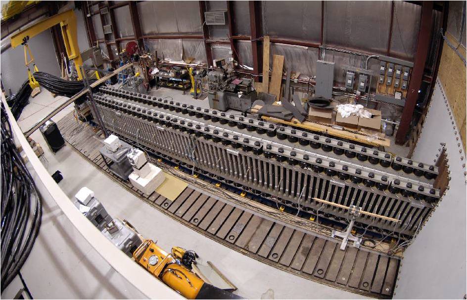 a long metal rail above a series of rectangular magnets inside a hangar