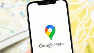 An image of a photo displaying the Google Map logo with maps in the background