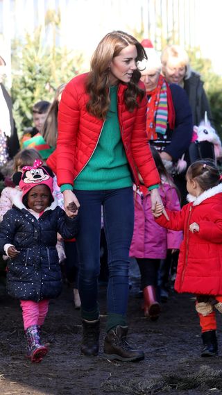 Catherine, Princess of Wales speaks to young children as she helps pick Christmas trees for preschool during a visit at Peterley Manor Farm