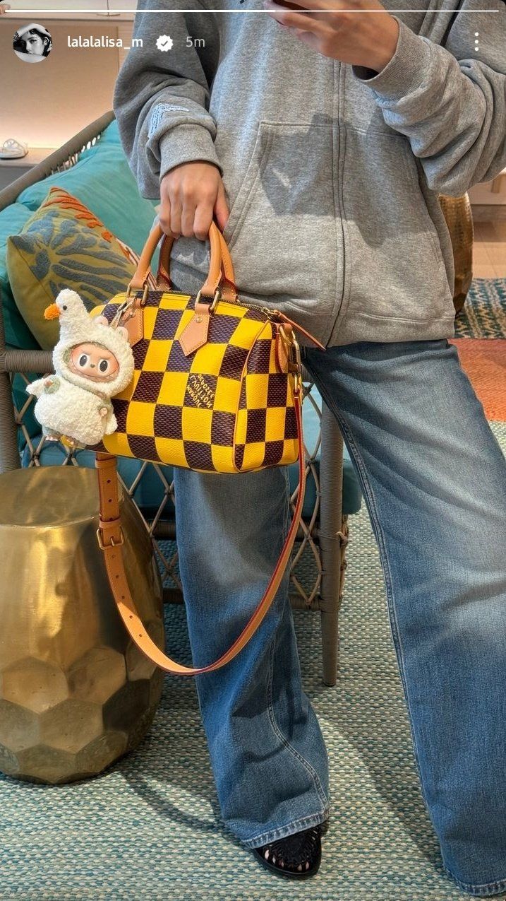 Lisa of Blackpink wearing yellow Louis Vuitton speedy bag with Labubu bag charm.