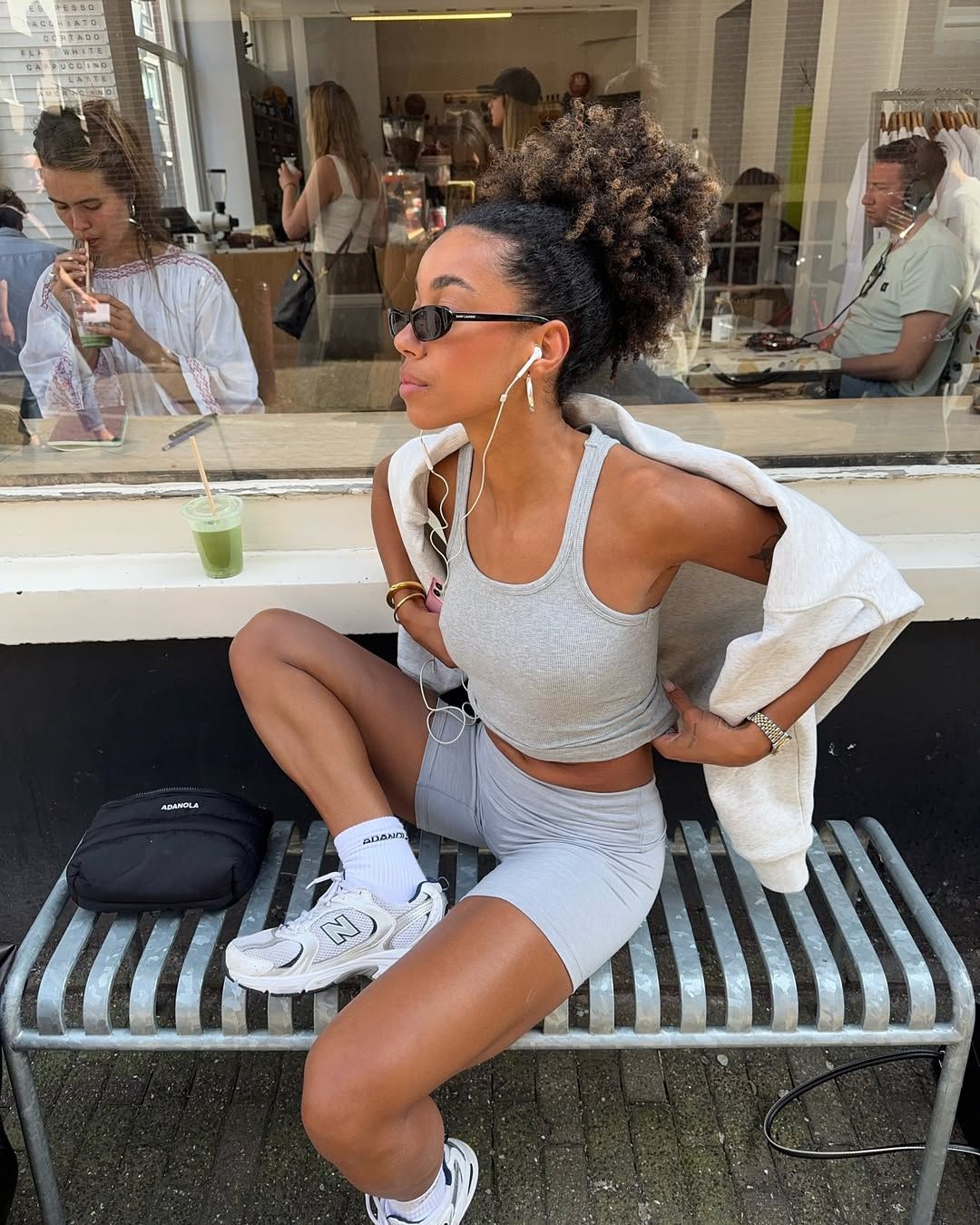 Amaka wears a gray tank top, gray bike shorts, and new balance sneakers.