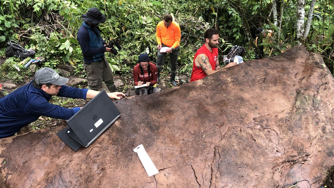 Another photo showing team members scanning the monolith. Rain is gradually eroding the rock and it's uncertain how long its carvings will be visible for.