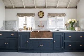 blue kitchen with copper basin, white walls, wooden roof, blinds, marble countertop and backsplash