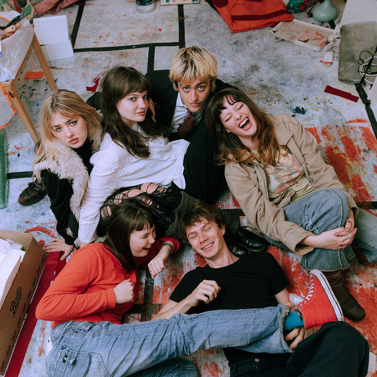 The six-piece Man/Woman/Chainsaw against an artistic floor background