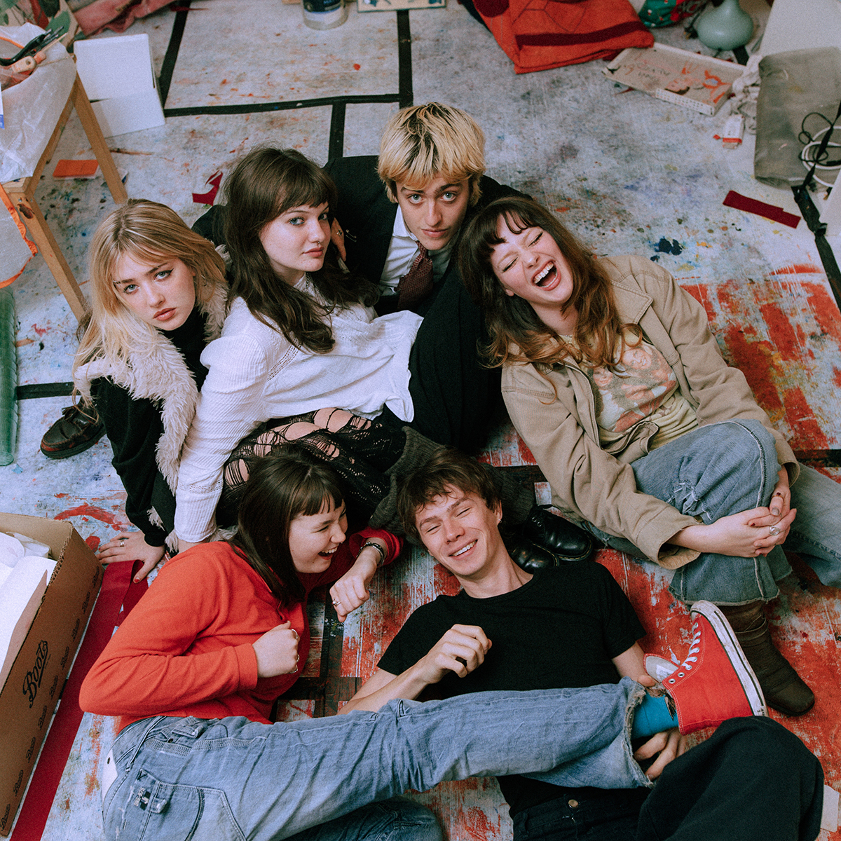 The six-piece Man/Woman/Chainsaw against an artistic floor background