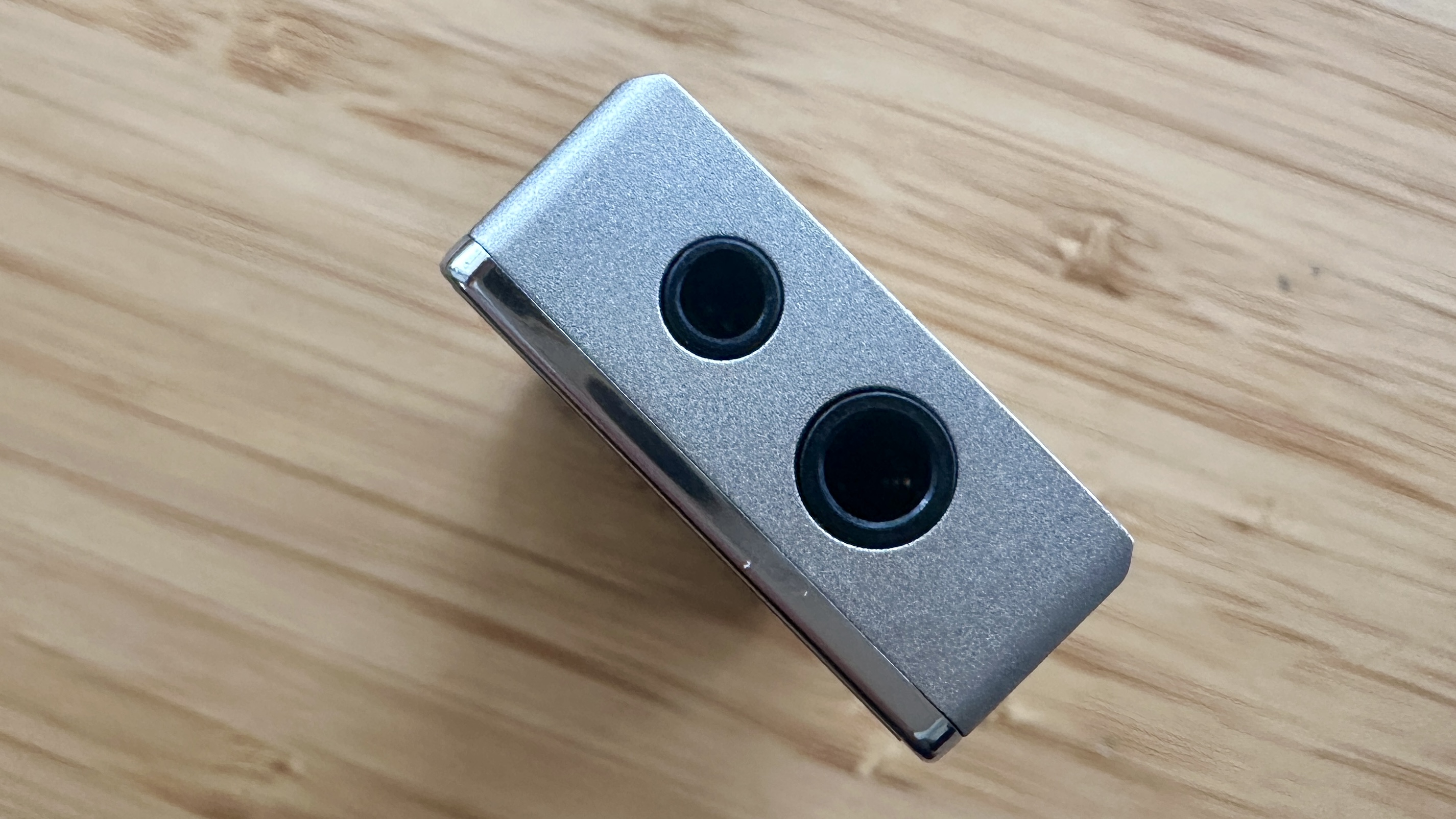 3.5mm and 4.4mm balanced ports of the FiiO QX13 headphone amp/DAC on a wooden surface
