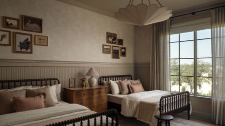 Whimsical double-dressed children's room featuring two beds, a floral light treatment, and collected art