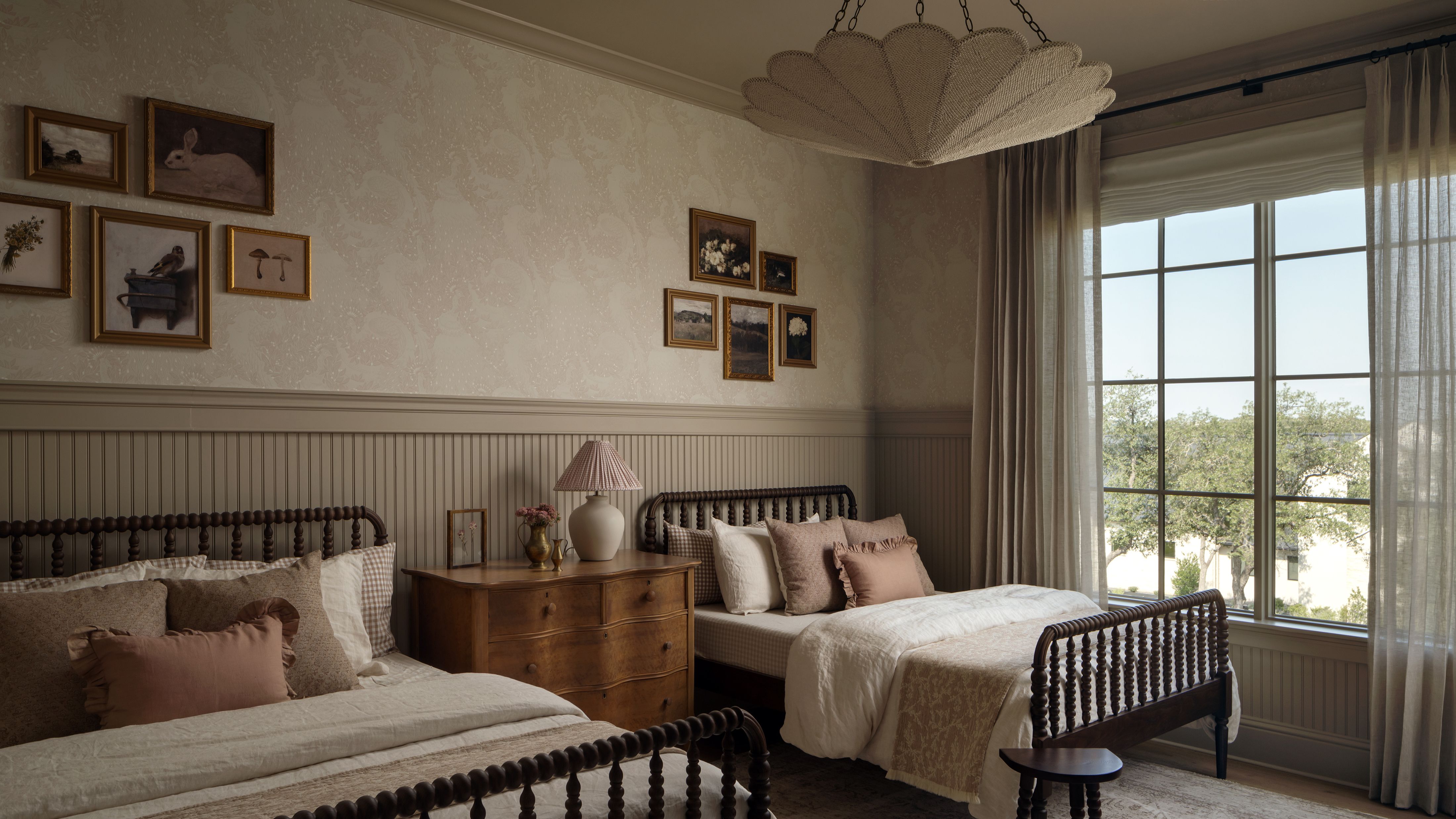 Whimsical double-dressed children's room featuring two beds, a floral light treatment, and collected art