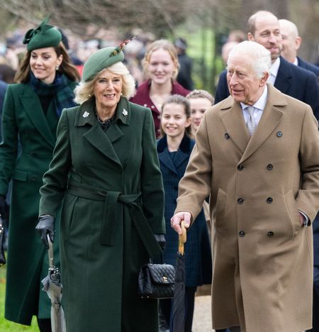 Kate Middleton, Queen Camilla and King Charles walking in wool coats on Christmas Day with Princess Charlotte, Prince William and Prince George behind them