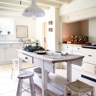 kitchen with white wall white cabinets wooden table and stool