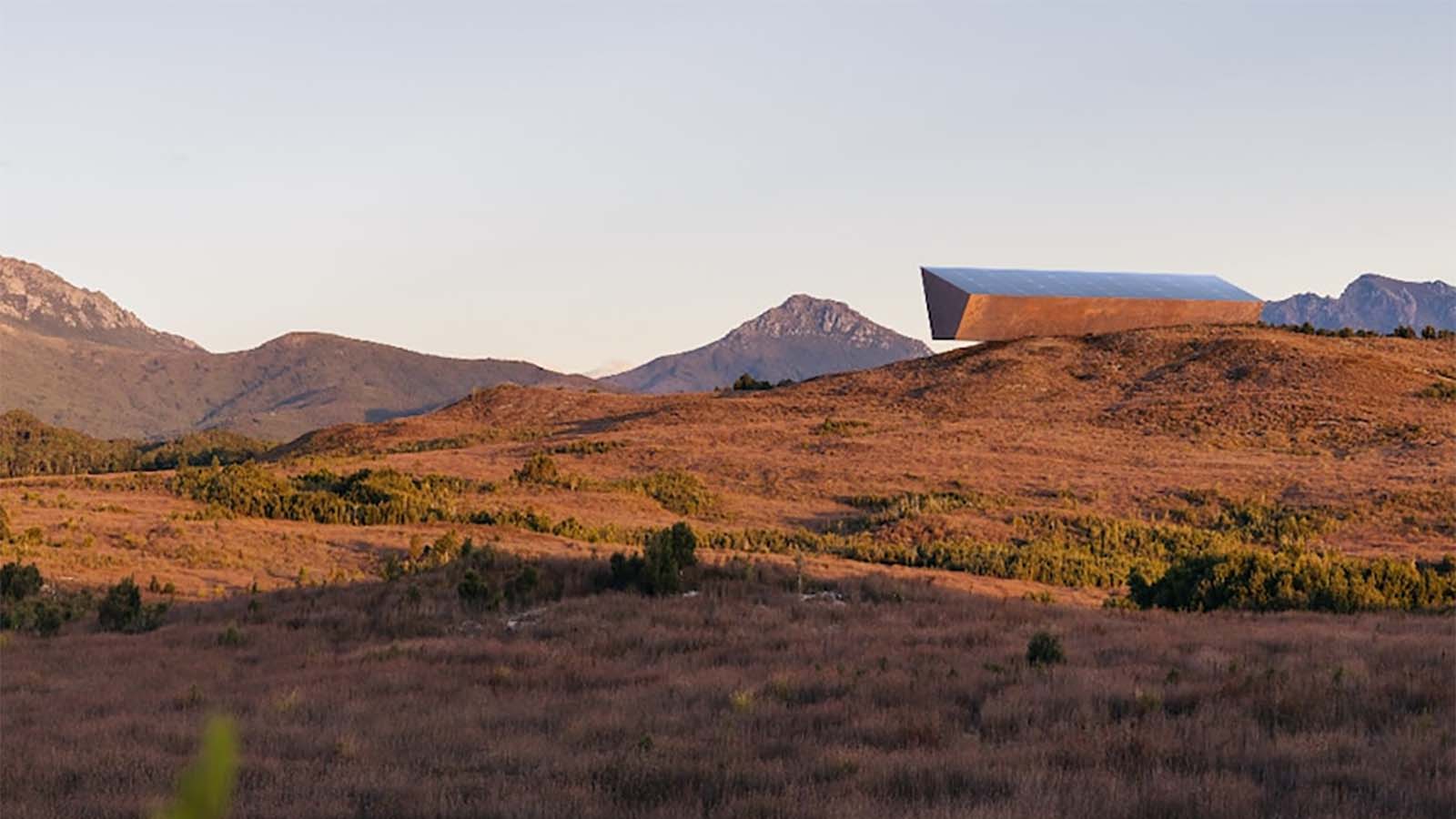 Earth's Black Box resting cantilever on a Tasmanian hill in the middle distance