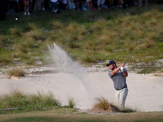 Bryson DeChambeau hitting a bunker shot at the 72nd hole of the 2024 US Open