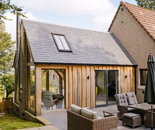 A pitched roof extension clad in timber with a roof light