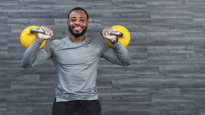 Man doing kettlebell ab exercises and smiling
