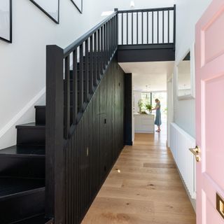 Large hallway with a wooden staircase painted black