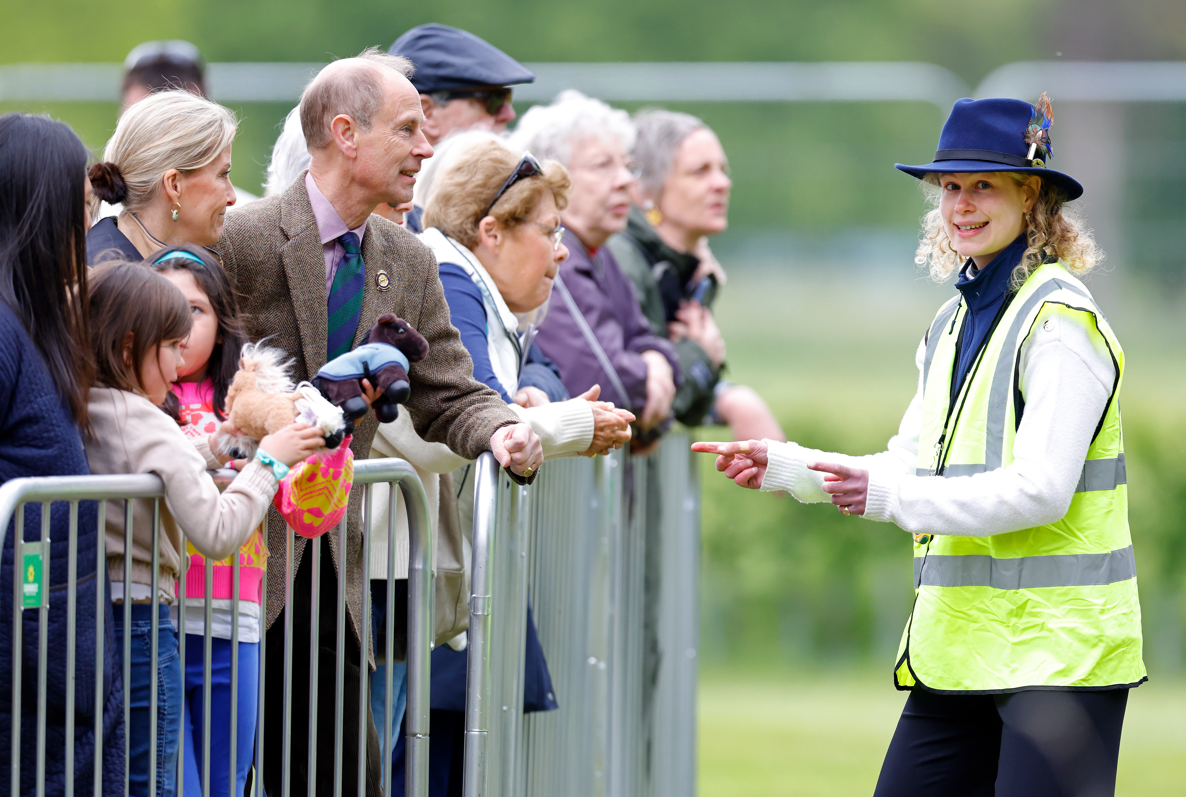 Lady Louise dressed in a high vis vest talking to Sophie and Edward leaning over a fence