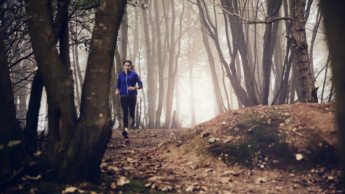 A woman running on a trail in the forest