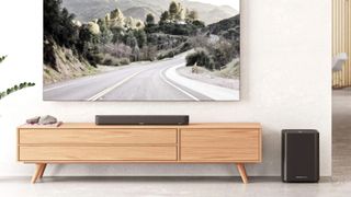 Sennheiser Ambeo Mini-soundbar op een houten meubel onder een tv