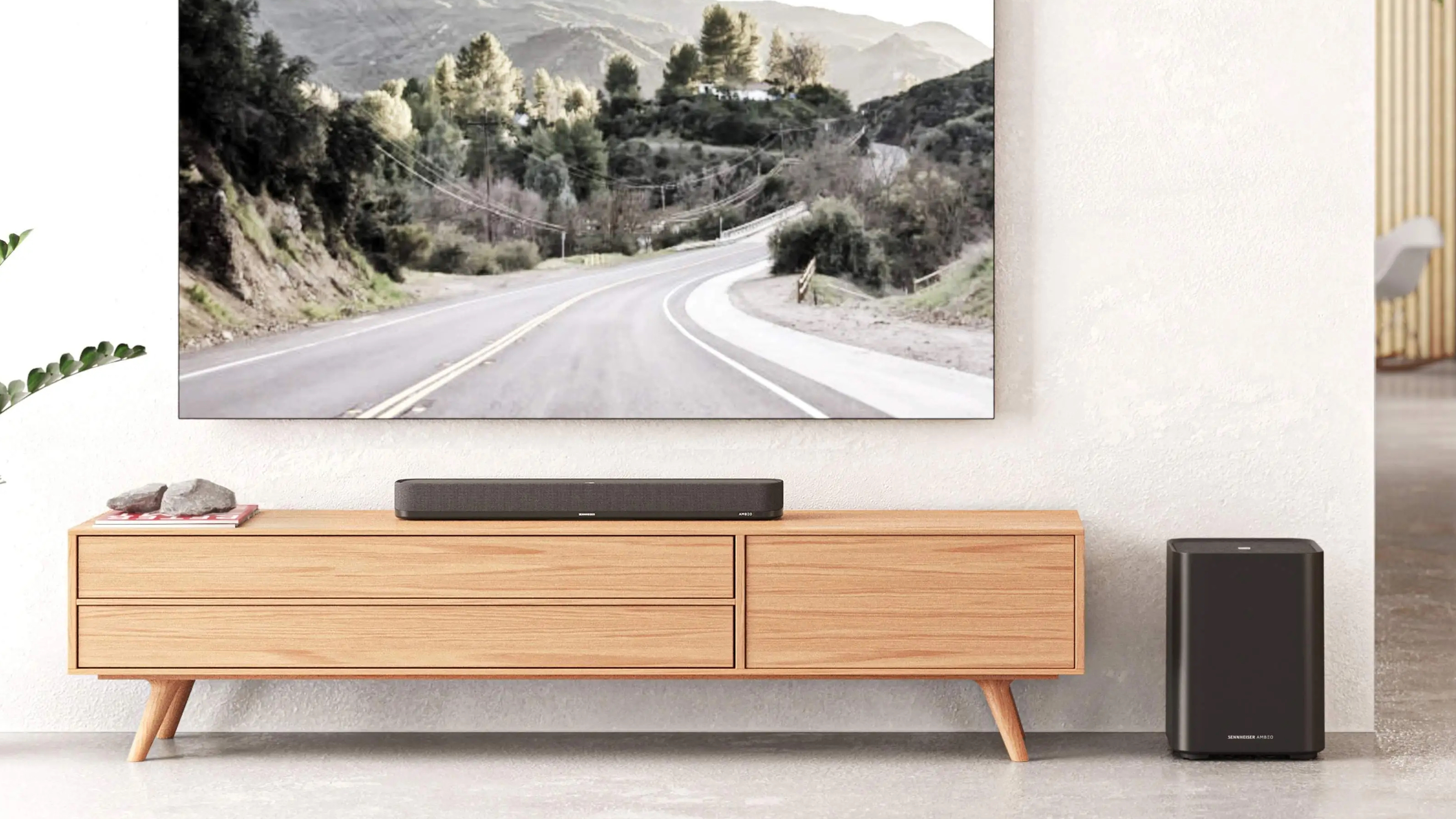 Sennheiser Ambeo Mini soundbar on a wooden surface below a TV