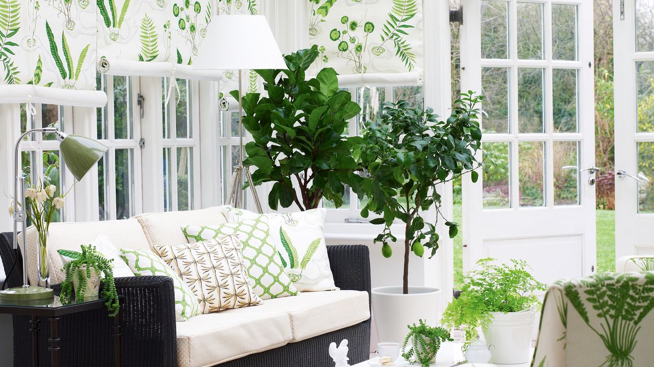 White conservatory with botanical printed armchair, cushions and blines