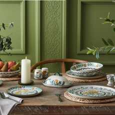 Nutmeg Wild Orchid collection on a wood dining table in front of a green period wall propery.