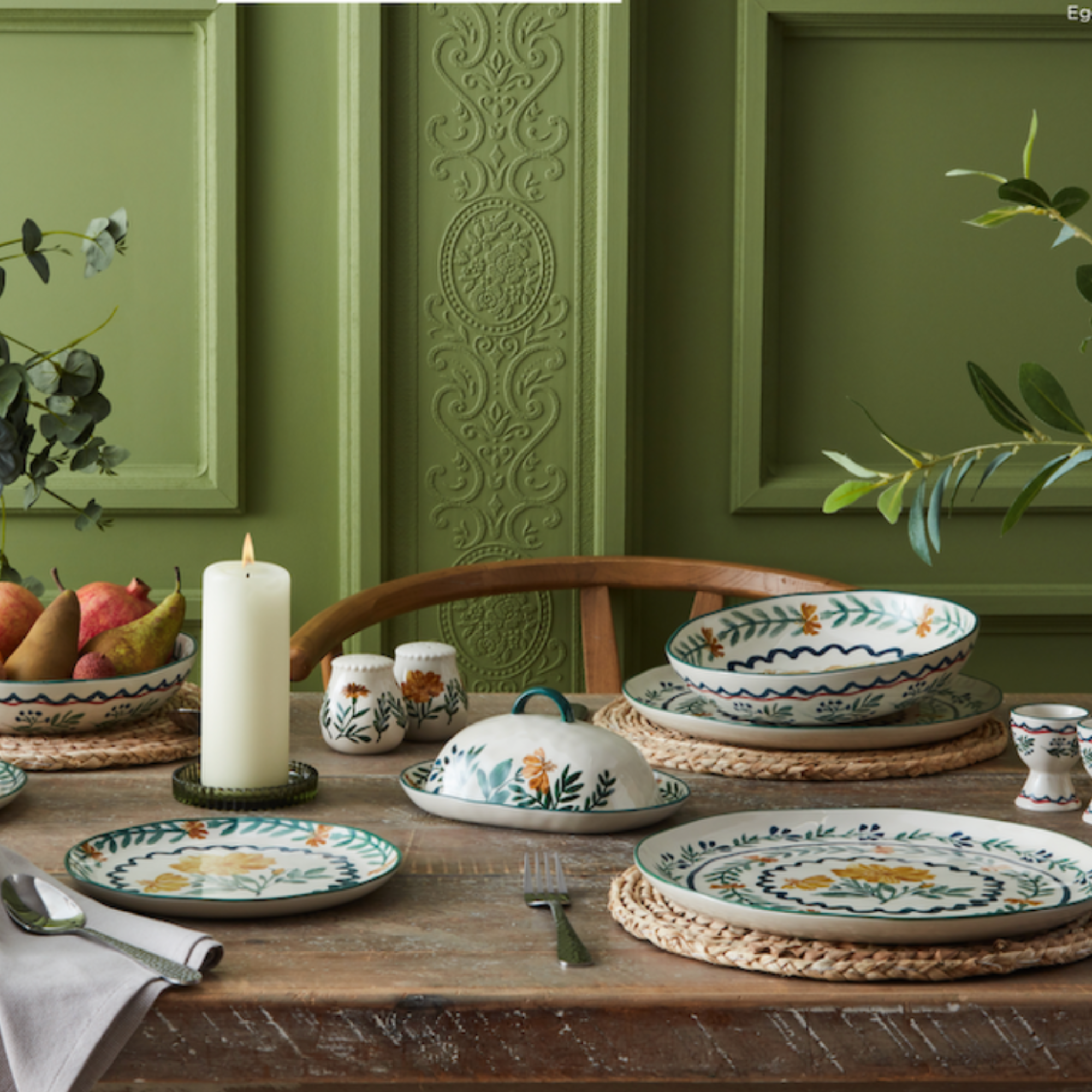 Nutmeg Dark Orchid collection on a wood dining table in front of a green period wall propery.
