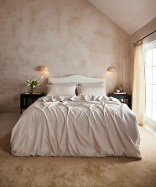 Oatmeal and White Stripe Bedding on a bed against beige walls.