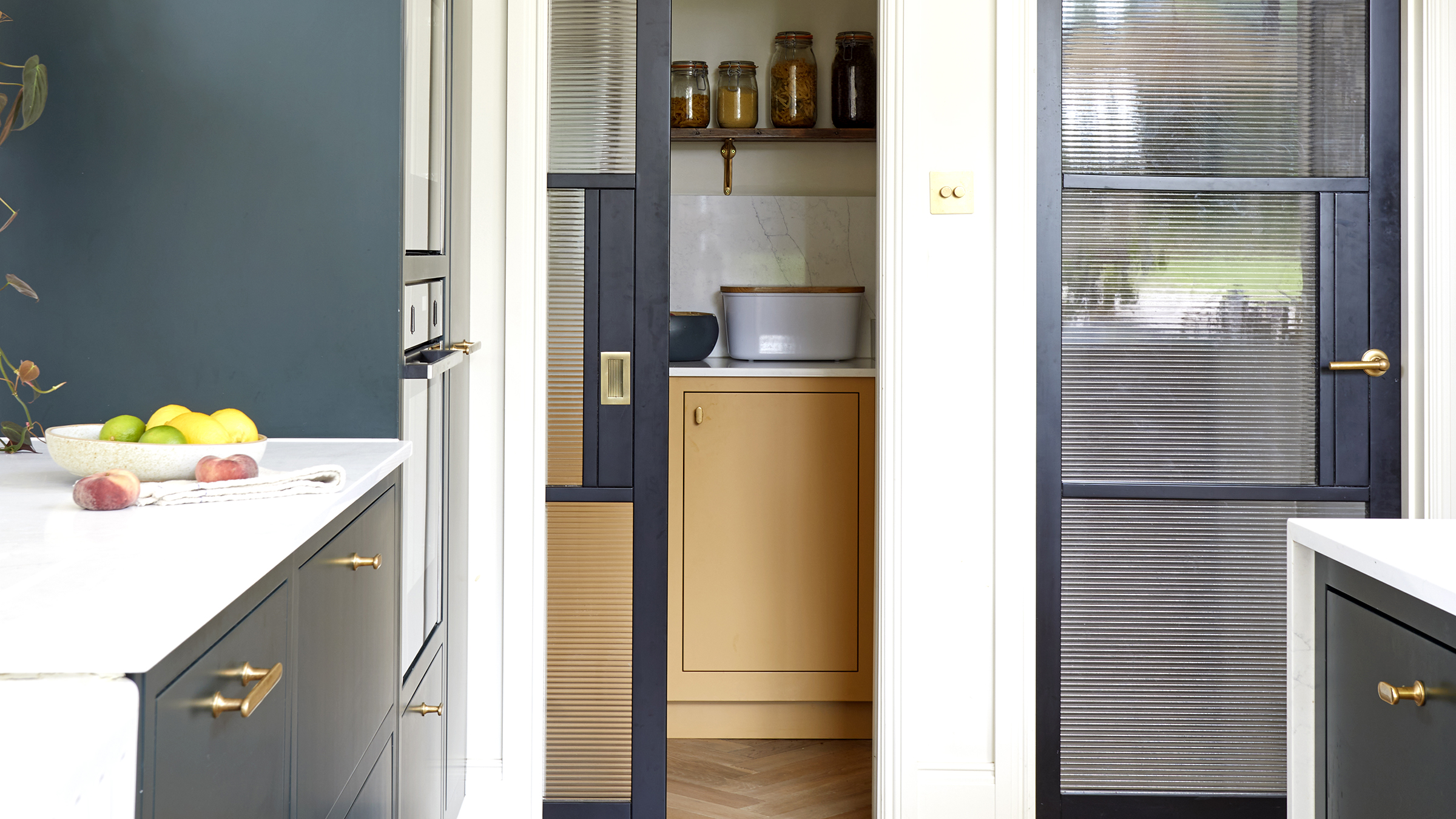 Walk in pantry in yellow in navy kitchen
