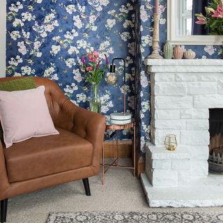 living room with blue and pink printed wall with leather chair and fire place