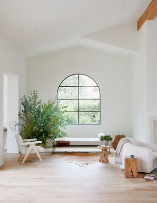 living room with daybed white walls steel windows