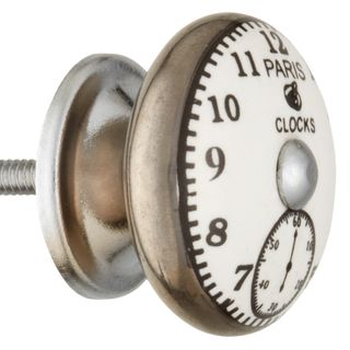 A metallic door knob with a white clock face design on the front of the knob.