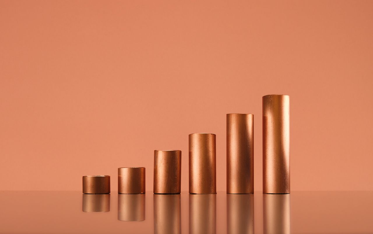 Copper tubes forming a growing bar graph, copy space. Commodity supercycle concept