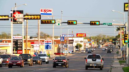 Photo of road with cars driving past gas stations