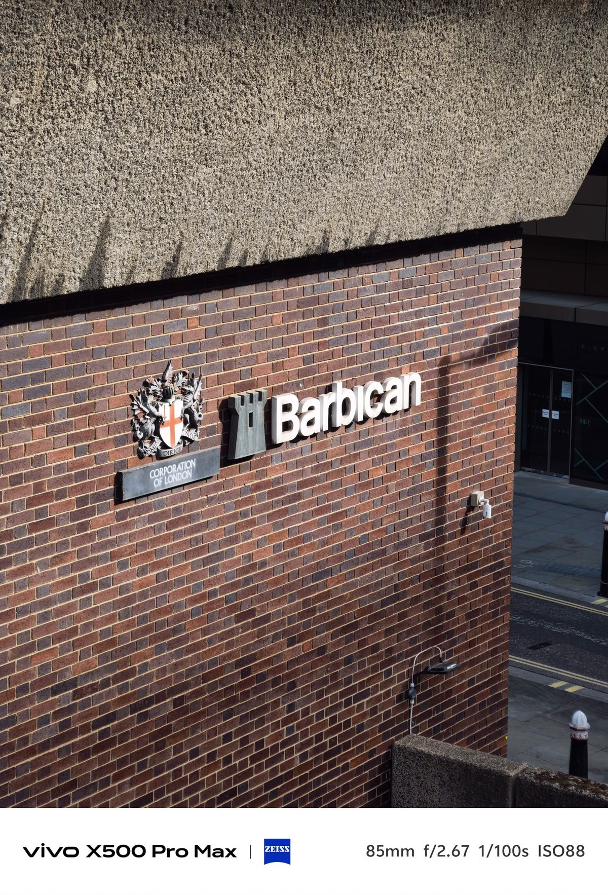 Barbican sign and City of London crest mounted on a brick wall.