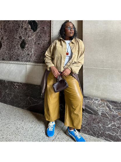 Editor Aniyah Morinia wearing neutral outfit with blue sneakers