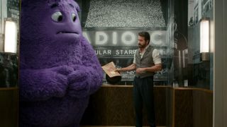 An imaginary friend stands in the corner next to Ryan Reynolds in IF