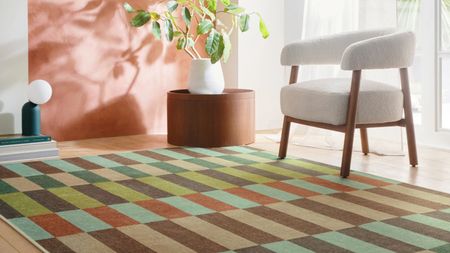 Hug Rug x Livingetc Modular Stripe Earth Eco-Washable Rug next to boucle armchair, planter, and lamp