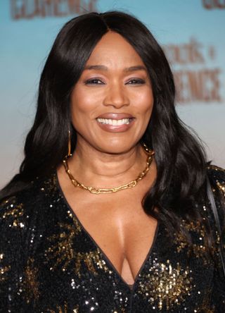 Actress Angela Bassett smiles in her low cut black dress with sparkly god embellishments