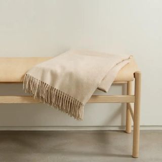 A tan blanket sitting on a bench