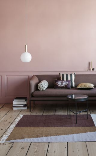 Dark brown leather sofa against pink wall