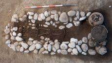 Pit tomb with a skeleton surrounded by rocks uncovered near Amorosi, Italy.