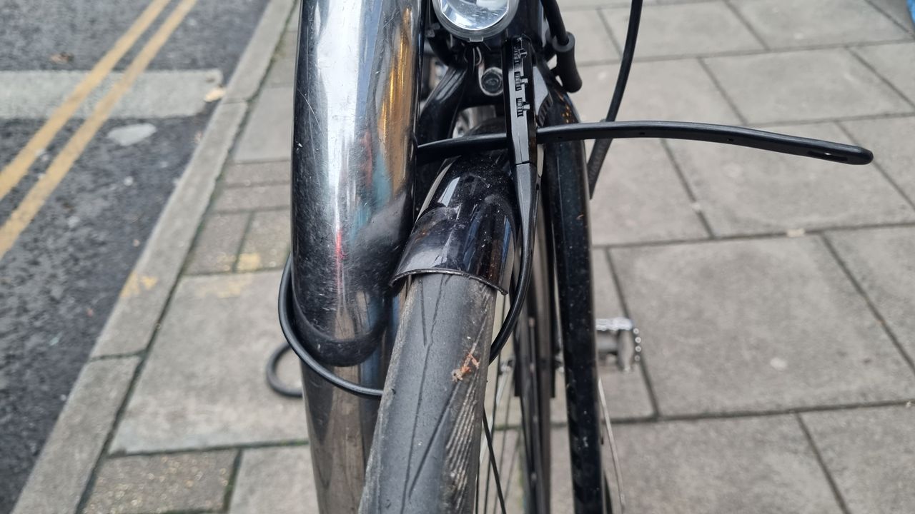 A Hiplok Z Lok Combo securing the front wheel of a road bike to a Sheffield stand