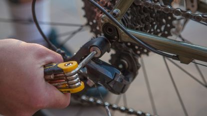 Image shows a rider using one of the best cycling multi-tools.