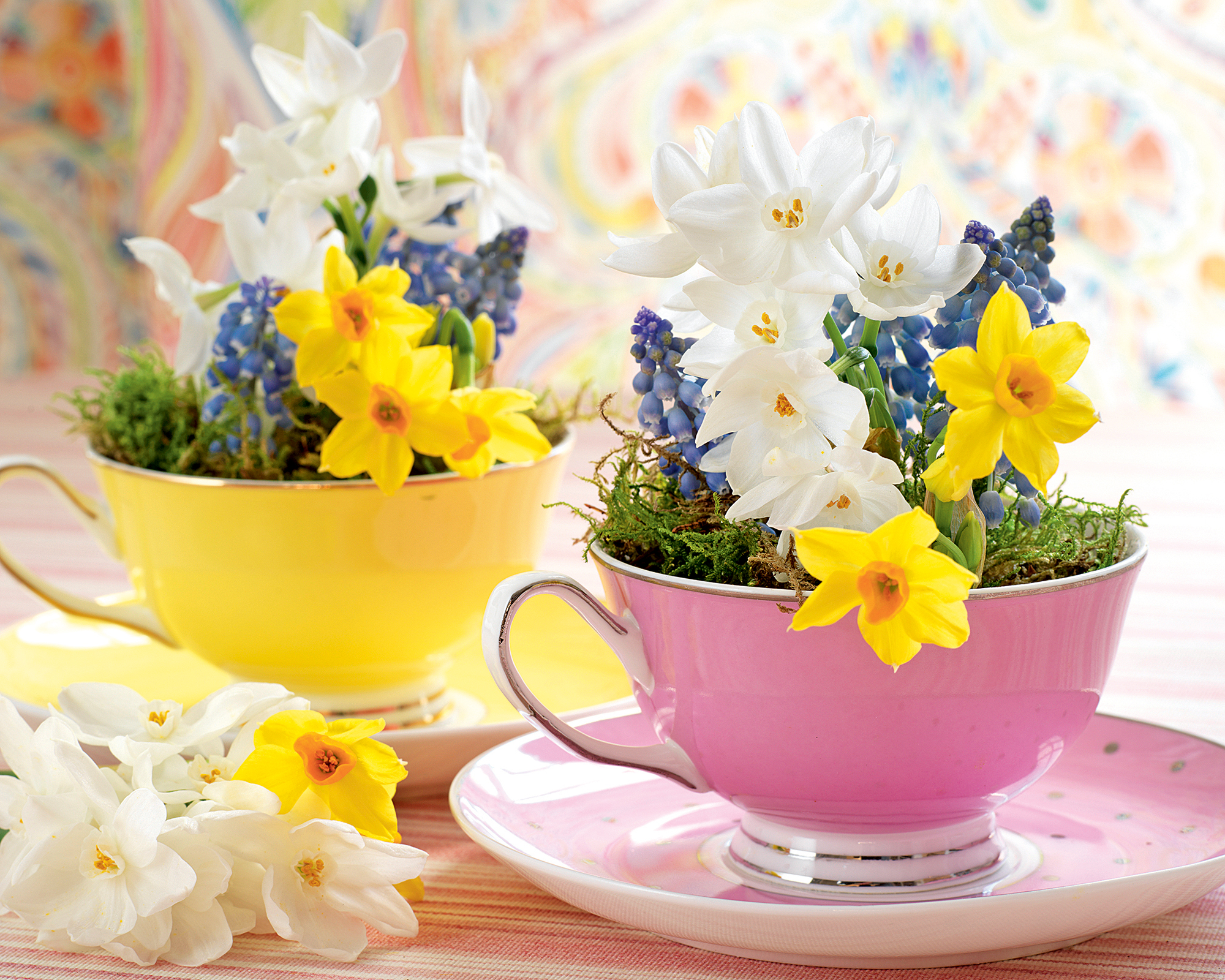 Tea cups and saucers filled with spring flowers