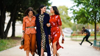 A group of women wearing orange clothes seen walking on the