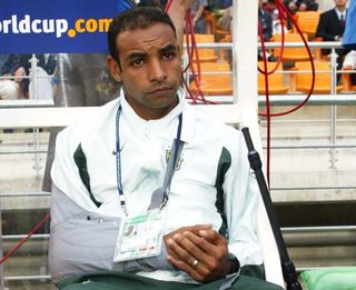 Sitting on the bench with his arm in a sling, Brazil midfielder Emerson watches his team-mates in action against Turkey at the 2002 World Cup.