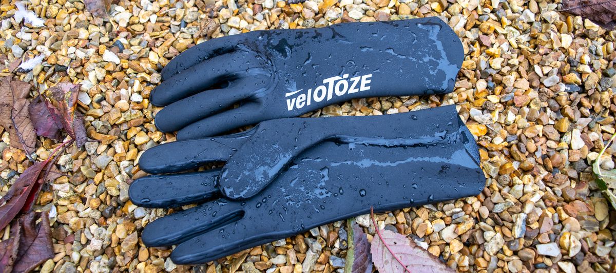 Velotoze neoprene gloves on some gravel with water droplets on them