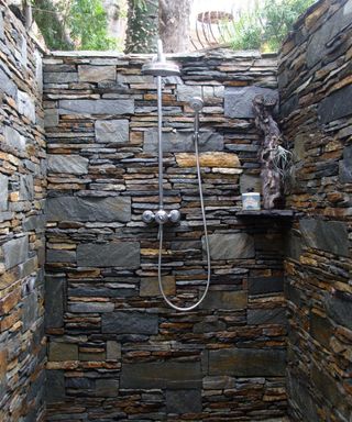 outdoor shower with stone wall enclosure