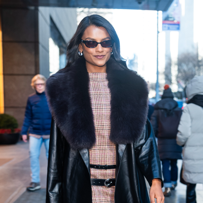 Simone Ashley wearing sunglasses and a fur-trimmed coat